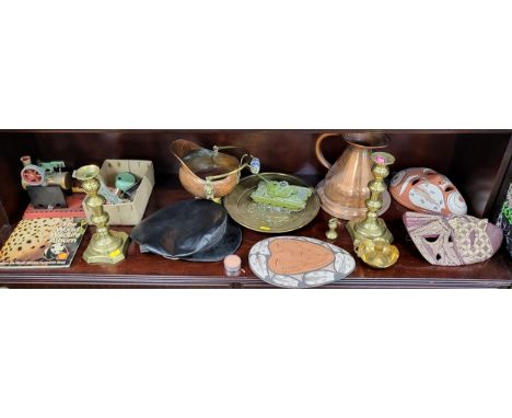 A collection of brass and copperware, masks, a toy tank, a cap, and a World Wildlife album.