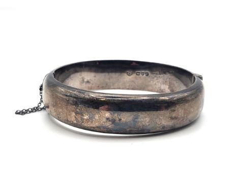 A silver hallmarked hinged bangle with safety chain, Joseph Smith &amp; Sons (Birmingham) Ltd, Chester 1956.