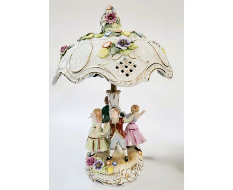 A porcelain lamp base with four dancing figures of children and porcelain shade with encrusted flowers 40cm.