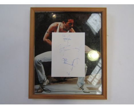 QUEEN: A white paper slip signed in blue felt tip pen by Freddie Mercury, Brian May, Roger Taylor and John Deacon 13cm x 10cm