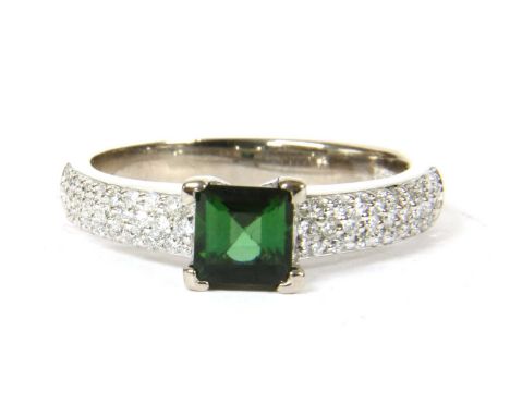 An 18ct white gold green tourmaline and diamond ring, a square step cut green tourmaline, claw set, to parallel shoulders pav