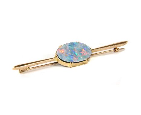 A gold opal doublet bar brooch, an oval opal doublet, 19.7 x 12.7mm, claw set to a plain collet at the centre of a slightly t