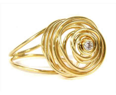 An 18ct gold diamond ring by Tous, a brilliant cut diamond, rub set to wire cage head and two row wire shank. Birmingham. Hea