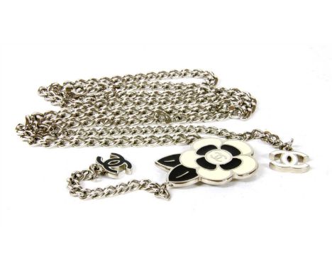 A Chanel chain belt, the white metal curb link belt with a white and black enamel floral buckle with central Chanel logo to o