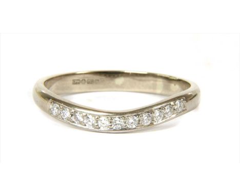 An 18ct white gold diamond ring, a row of brilliant cut diamonds, grain set to the curved head, with plain D section shank. B