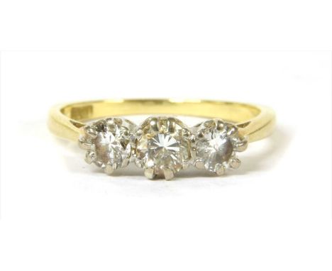 A gold three stone diamond ring, a row of graduated brilliant cut diamonds, claw set in white, to yellow tapered chenier shou