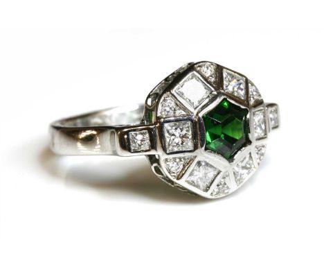 An 18ct white gold tsavorite garnet and diamond cluster ring, an hexagonal step cut tsavorite garnet, rub set to the centre, 