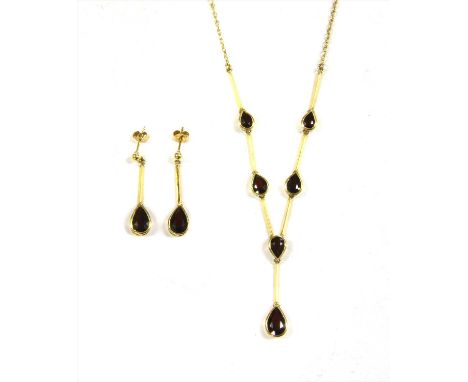 An 18ct gold garnet 'Y' necklace and earrings suite, the necklace with a pear cut garnet drop suspended from a central pear c