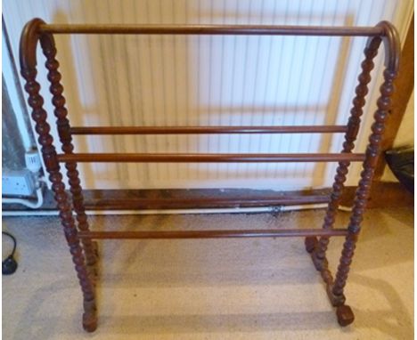 AN EDWARDIAN STAINED BEECH TOWEL RAIL with bobbin turned end supports 