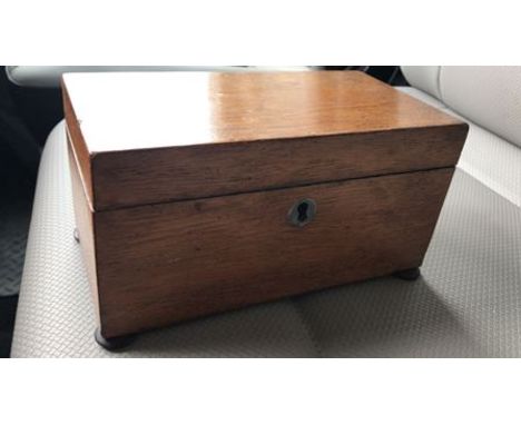 AN EARLY 19th CENTURY GEORGIAN MAHOGANY TEA CADDY with original fitted interior, raised on bun feet. 