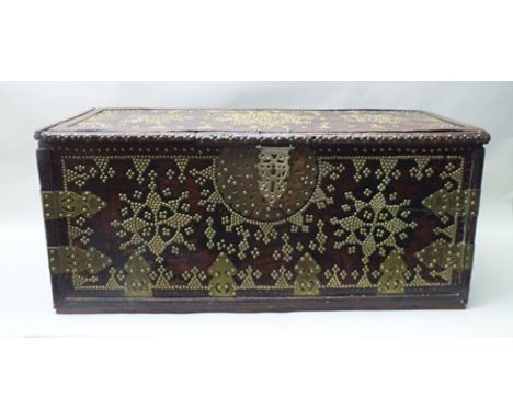 A DECORATIVE FAR EASTERN WOODEN TRUNK profusely brass studded, having plain rectangular form with lift-up lid, vacant interio