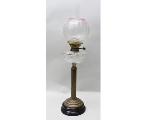 A 19TH CENTURY BRASS COLUMNED OIL LAMP with cut glass reservoir, etched globular shade with pink highlights, 76cm high to top