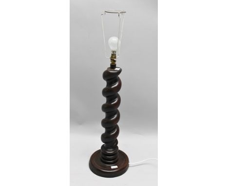 A SUBSTANTIAL TABLE LAMP formed from part of a barley twist column, 64cm high, on a dished base, with green shade 