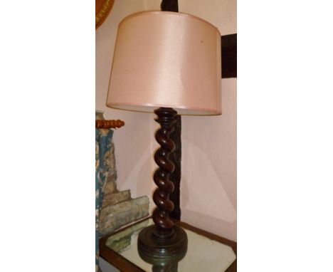 A MAHOGANY TABLE LAMP made from a portion of bed post, in deep barley twist design, on a dished turned base, complete with pi