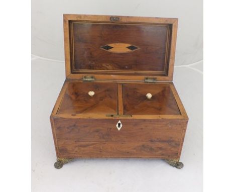 AN EARLY 19TH CENTURY YEW-WOOD TEA CADDY with metal fittings, opening to reveal twin caddy boxes with lids, decorative ring m