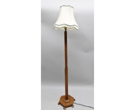 A 20TH CENTURY OAK STANDARD LAMP raised on hexagonal platform base, fitted shade 