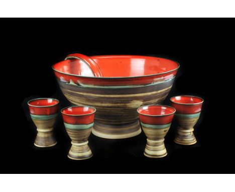 A studio pottery punch bowl,  with red and turquoise partial glaze, together with ten goblets and ladle en suite (12)