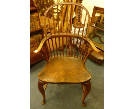 An early 19th century Windsor comb-back arm chair,  on cabriole legs, and united by an H stretcher, 100.5cm