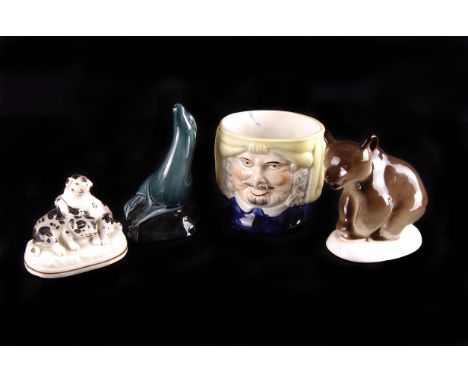 A 19th century Staffordshire pottery puppy group, together with a Staffordshire tobacco jar, a Poole pottery seal, and a figu