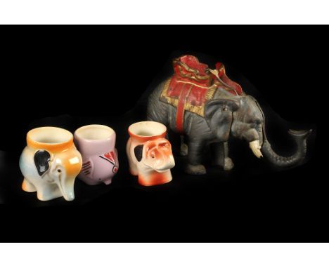 A vintage cold painted cast iron mechanical elephant money bank,  20cm long, together with a group of ceramic elephant orname