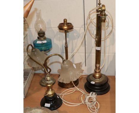 ~ Four late Victorian lamps comprising: a brass example with scrolled arm support with later painted shade; an oil lamp with 