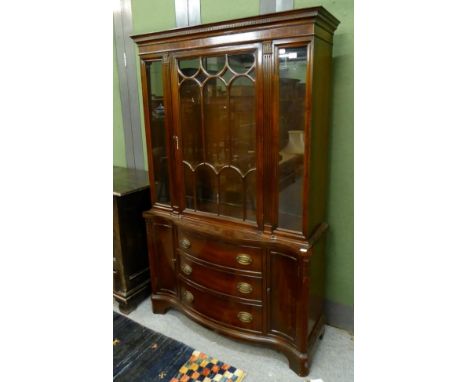 A reproduction mahogany bookcase in George III style, with glazed door between fluted stiles, the base of serpentine shaped f