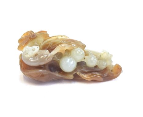 A Chinese white and russet jade carving depicting squirrels playing amongst foliage alongside a dragonfly, 5.8cm long