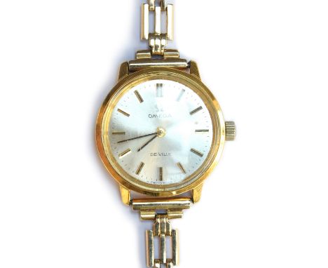 An Omega de Ville lady's watch, on 9ct gold bracelet, the brushed silvered dial with baton markers, approx. 22mm diameter, gr