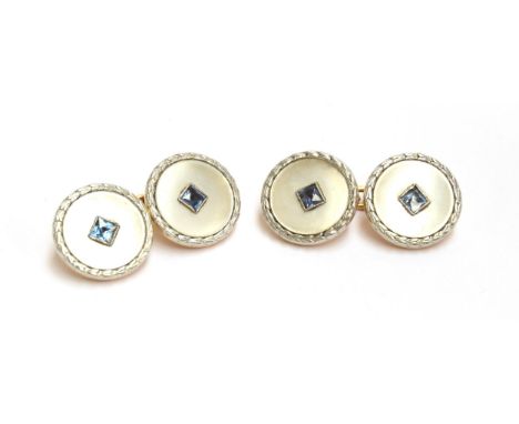 A pair of Art Deco 18ct gold, platinum and mother of pearl cufflinks set with a French cut sapphire within a milgrain setting