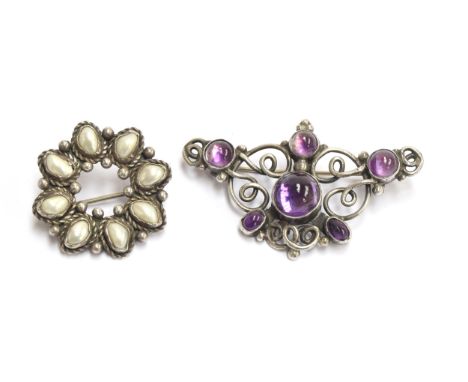 A small collection of Arts and Crafts jewellery to include an amethyst cabochon brooch, 5.4cm wide, a silver and pearl wreath