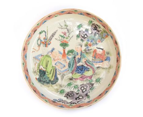 A Chinese export porcelain dish, decorated with a scene depicting a scholar at his desk accompanied by a flute player and his