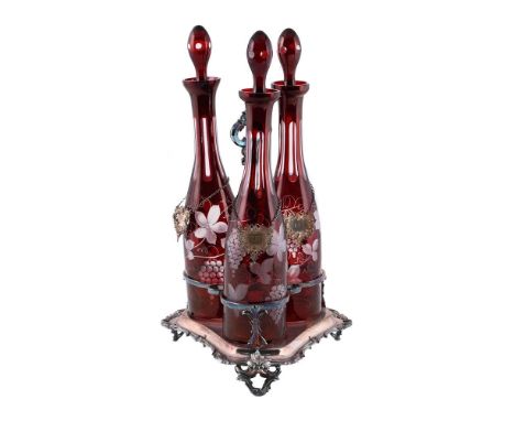 An English silver-plated decanter stand, with three ruby-flashed and engraved glass decanters and stoppers, c.1860, with mode