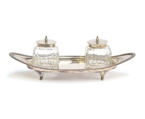A George V silver and cut glass ink stand by Atkin Brothers, Sheffield 1914, of navette form, with gadrooned edge, having two