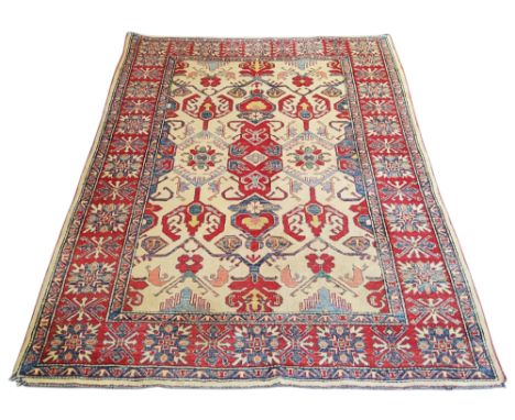 An early 20th century oriental rug, Nomadic design, in red, ivory and blue, 238cm x 170cm