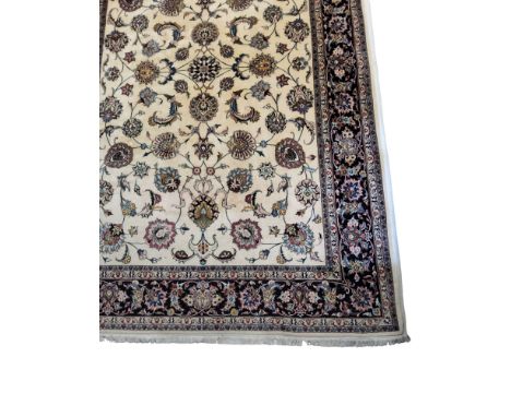 A Persian woollen &nbsp;rug or carpet, with stylised flowers and geometric motifs, in tones of red, blueand ochre, on a cream