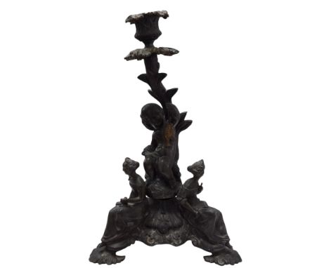 A Victorian bronze figural candlestick, the sconce and capital supported by a Cherub riding a fish holding gilded fish aloft,