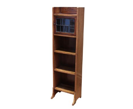 An Edwardian satinwood and mahogany narrow part-glazed bookcase - the open shelf top over a leaded glazed door and three furt