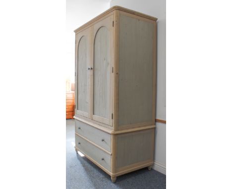 A 19th century style painted pine linen press - the shallow moulded top over a pair of arched panelled doors, enclosing a han