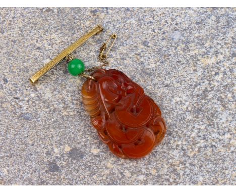A mid-century Chinese carved jade plaque on bar brooch - the ovoid, russet jade plaque pierced and carved with a bat and mone