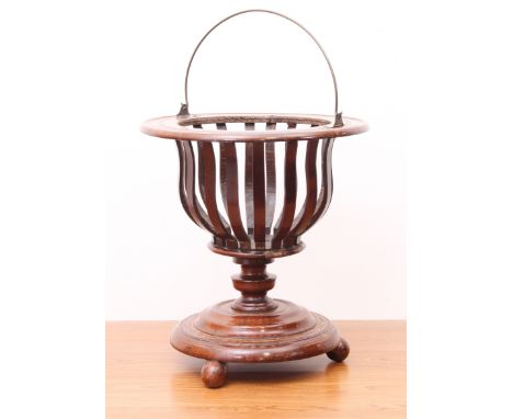 A 19th century mahogany basket jardini&egrave;re - with brass swing-handle, urn-shaped slatted body and turned urn stem to a 