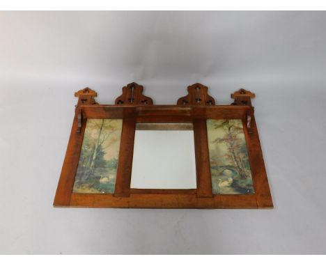 A Victorian gothic oak over mantel mirror, with a narrow shelf over a bevelled glass mirror flanked by a pair of panels conta