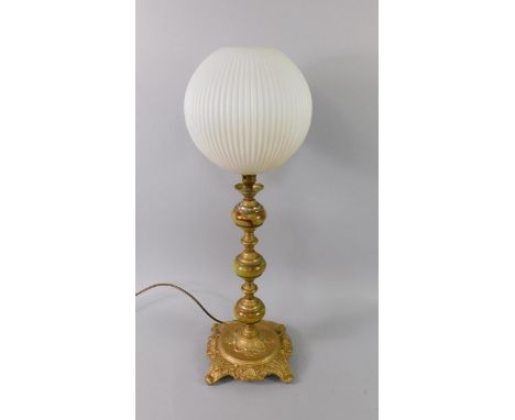 A 1970's onyx and brass table lamp, with cast leaf and shell decoration, fluted white glass shade, 71cm high.