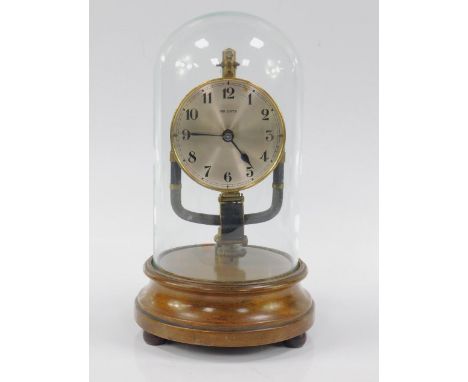 An 800 day electric mantel clock, converted to battery, silvered dial bearing Arabic numerals, on a circular wooden base with