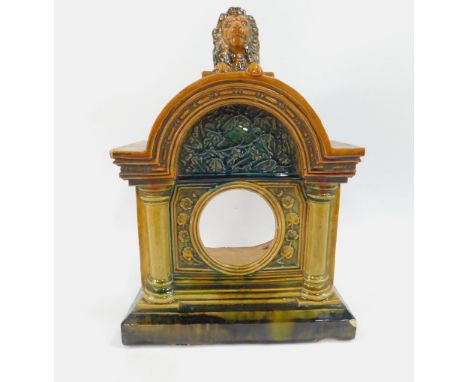 An Arts & Crafts late 19thC pottery mantel clock, by E.Smith & Co, Coalville, of architectural form surmounted a recumbent li