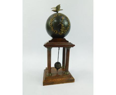 A Continental early 20thC orb clock, bearing Arabic numerals with bird surmount, thirty hour pendulum movement, on a beech po