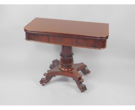 A Regency plum pudding mahogany card table, the demi-lune fold over top raised on a lappet carved column and quatrefoil base 