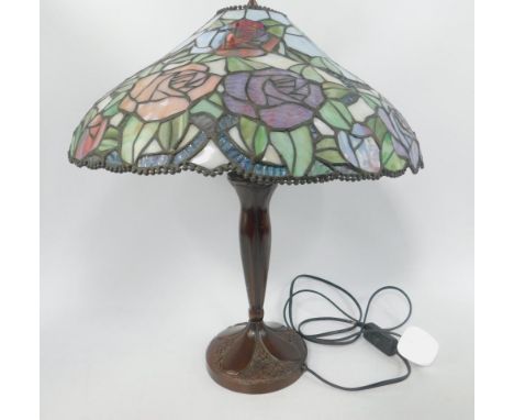 A Tiffany style table lamp with a glass shade decorated with roses.