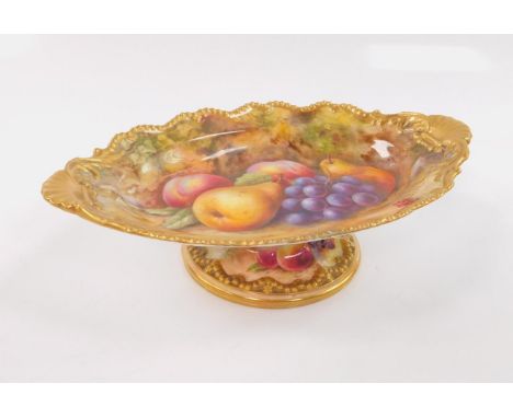 A Royal Worcester porcelain tazza painted with fruit by T Lockyer, c.1925, of oval pedestal form decorated with a gilt gadroo