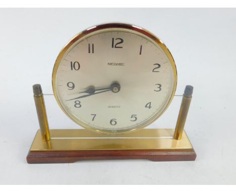 A Metamec quartz floating mantel clock, circular silvered dial bearing Arabic numerals, on a perspex and burnished brass fram