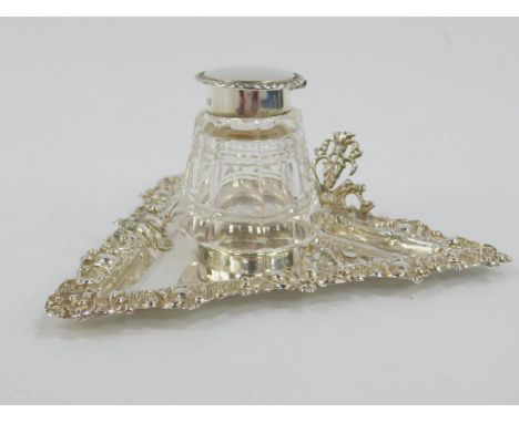 A Victorian cut glass and silver inkwell on stand, the triangular stand with an embossed foliate scroll border, 2.2oz, George